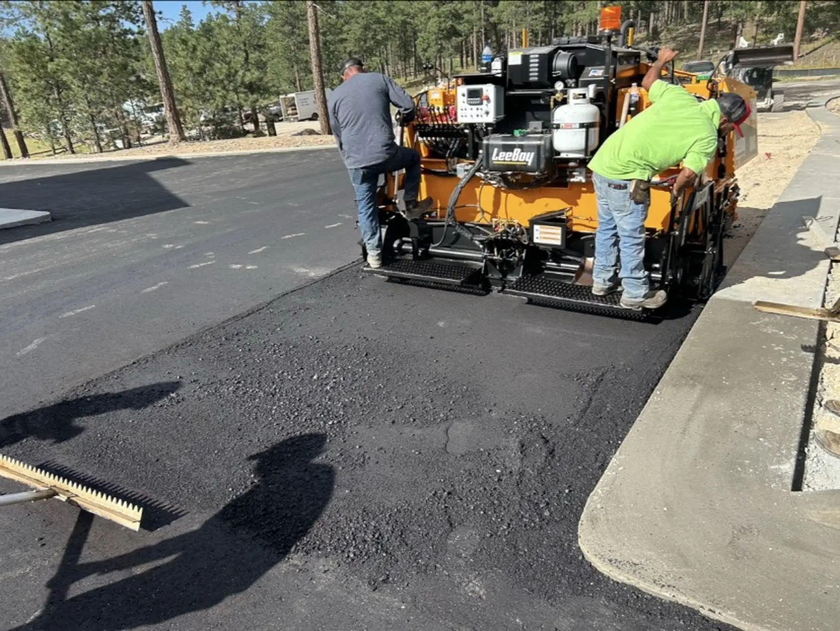 Olympic City Paving crew laying a hot asphalt mat with a paver in Colorado